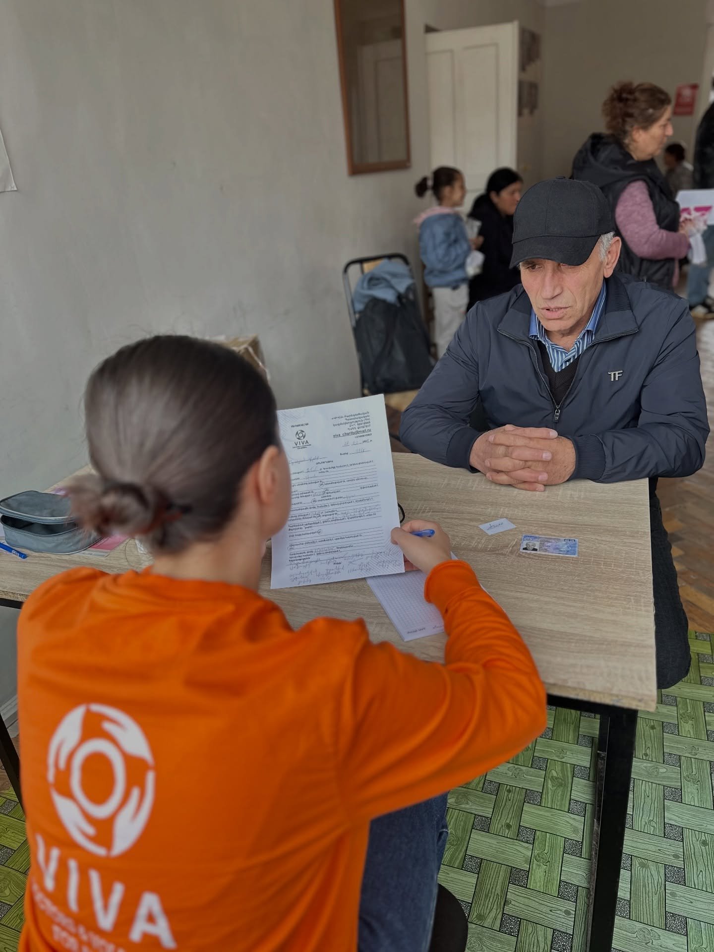 VIVA charity volunteer reviewing a healthcare assistance form with a man in Armenia